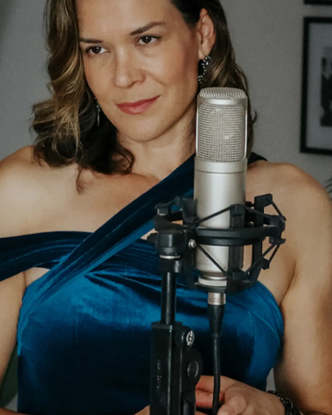 Nicola Milan in a blue gown singing